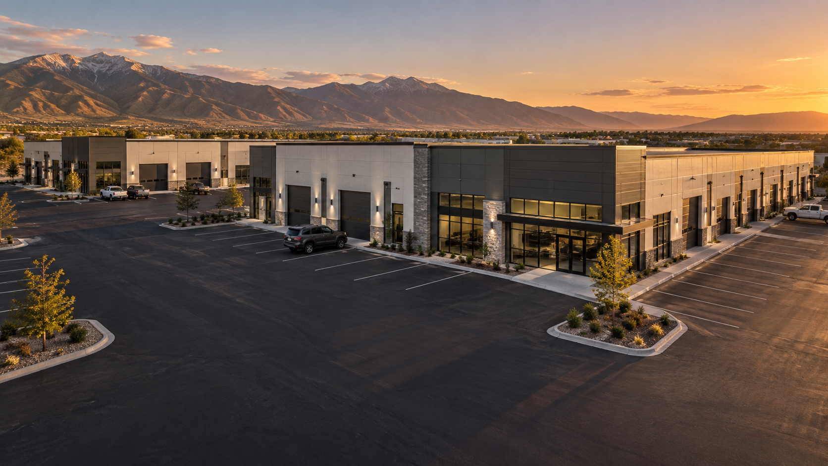 Illustrative modern flex-space buildings with a mountain backdrop at sunset